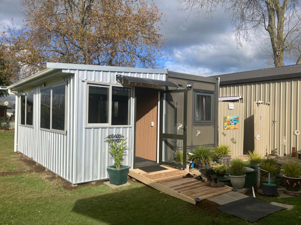 a tiny house with a porch and a deck at Cameo B&B in Matamata