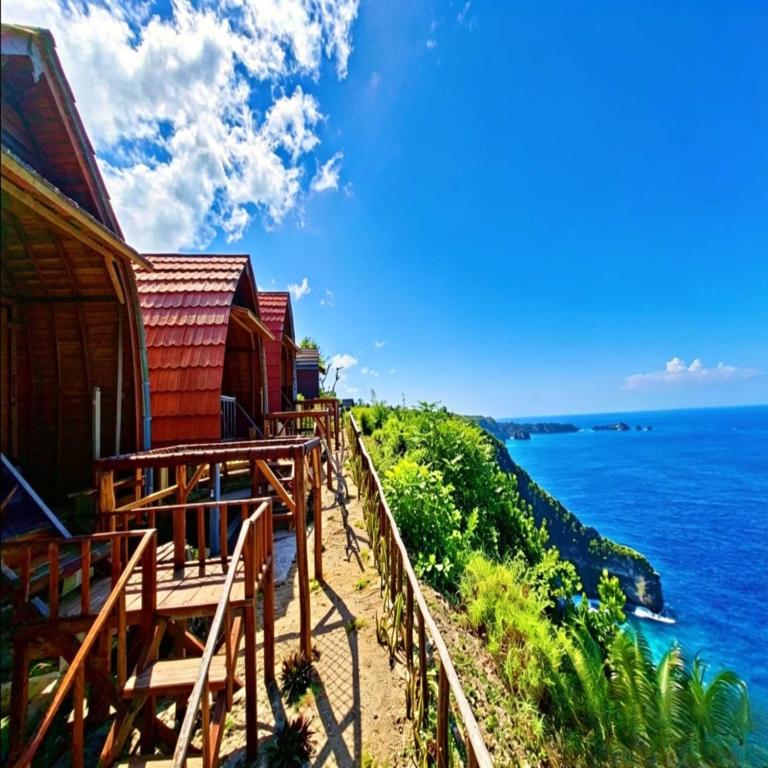 a row of houses on a hill overlooking the ocean at Suwehan Rey Cliff House in Nusa Penida