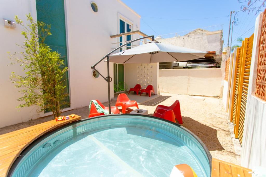 a small swimming pool with red chairs and an umbrella at Casa Mila in La Paz
