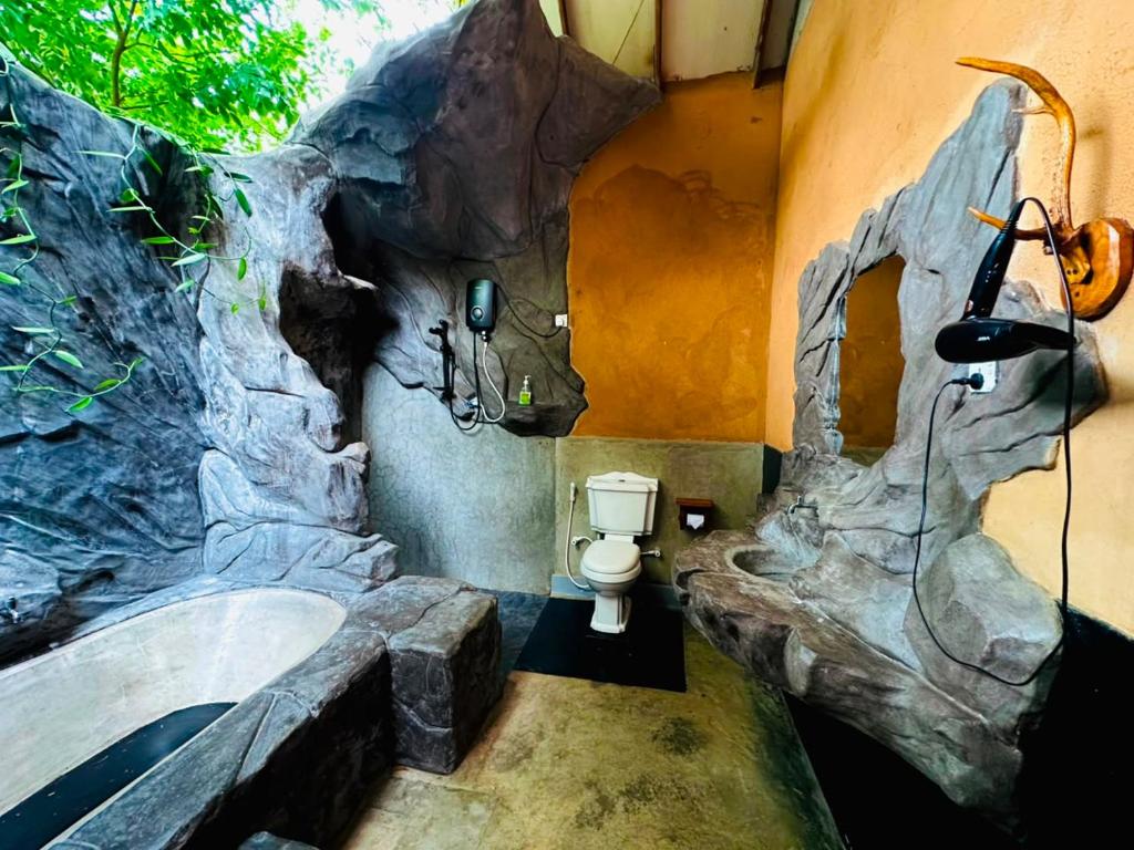 a bathroom with a tree branch painted on the wall at Ama Eco Lodge in Sigiriya