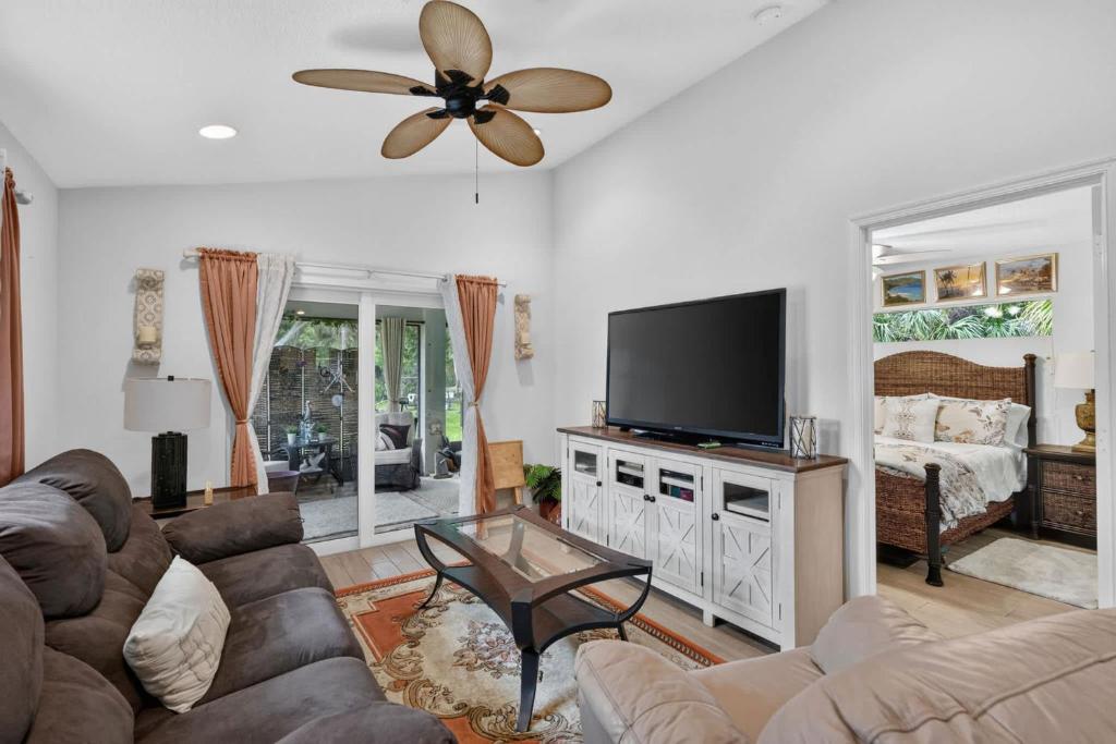 a living room with a couch and a flat screen tv at Abi's House - Private Jupiter Escape in Jupiter