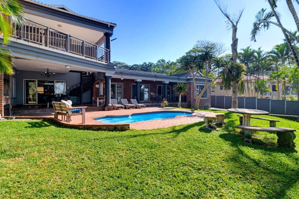 a backyard with a pool and a house at Palm View in Ballito