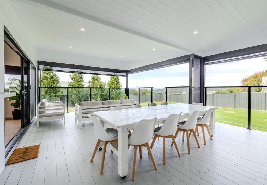 a white dining room with a large white table and chairs at Driftaway, Albany in Albany