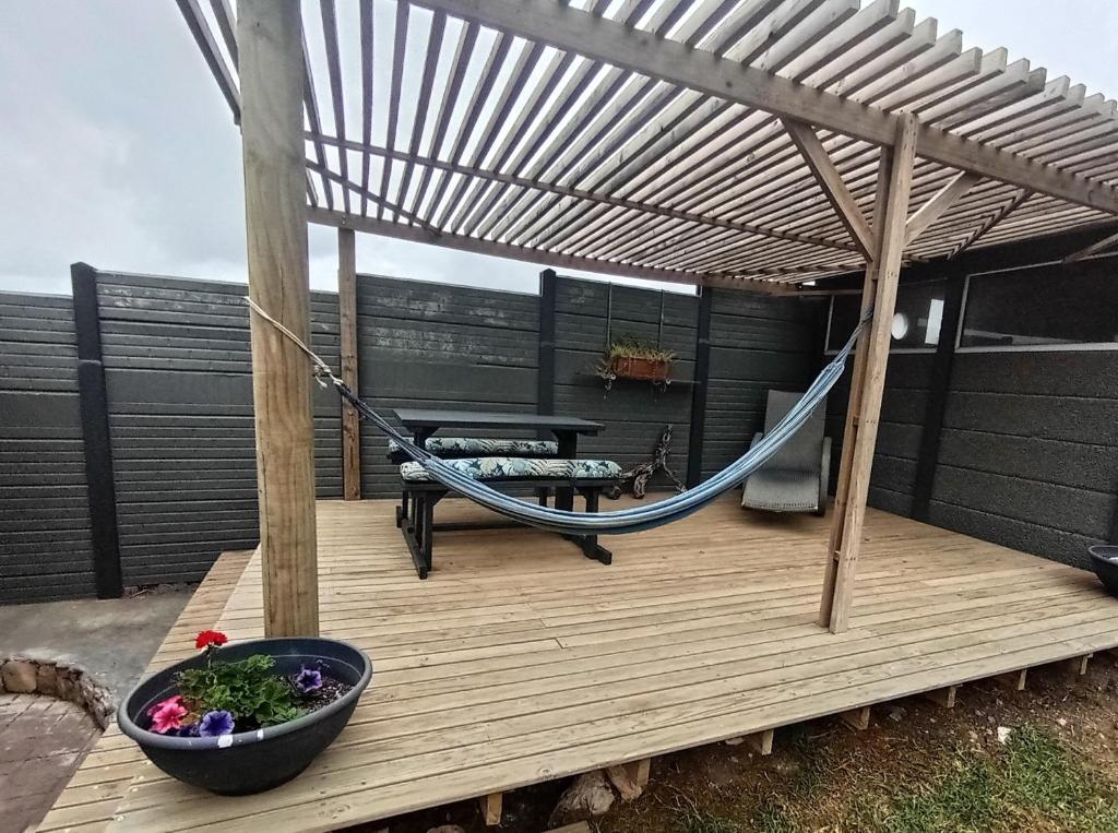 a deck with a hammock and a bowl of vegetables at Perdekuil in Stilbaai-Wes