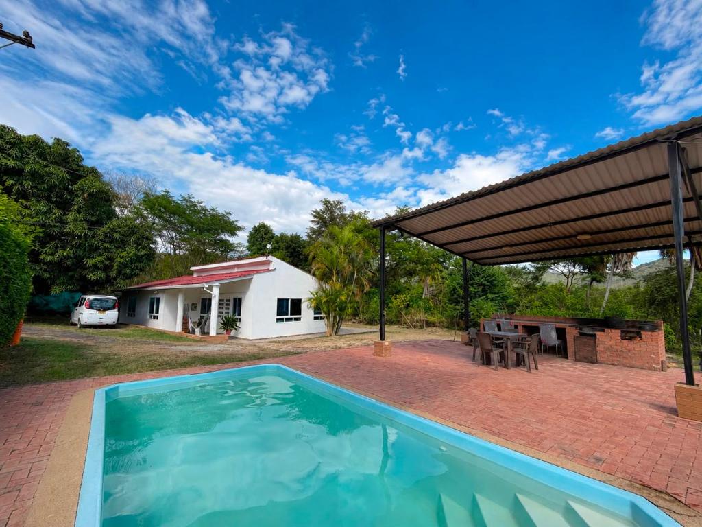a swimming pool in front of a house at Finca El Balmoral in Tocaima
