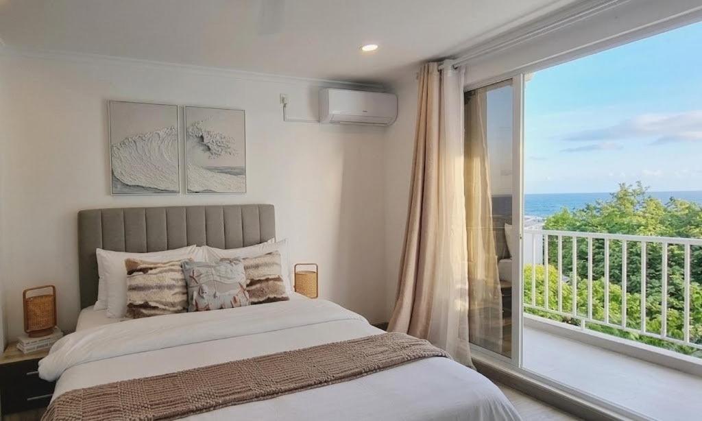 a bedroom with a bed and a large window at Nala Host - Maafushi Homes in Maafushi