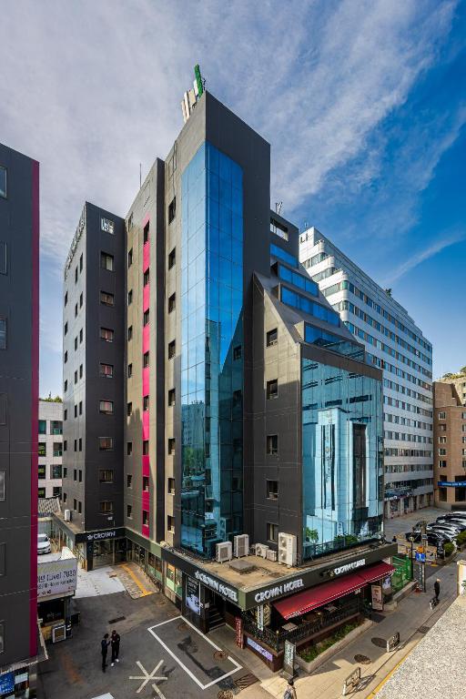 a large building with glass windows in a city at Insadong Crown Hotel in Seoul