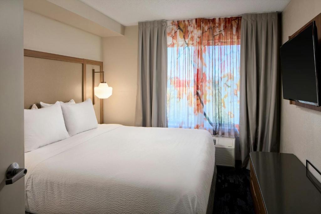 a hotel room with a white bed and a window at Fairfield Inn & Suites Cleveland Avon in Avon