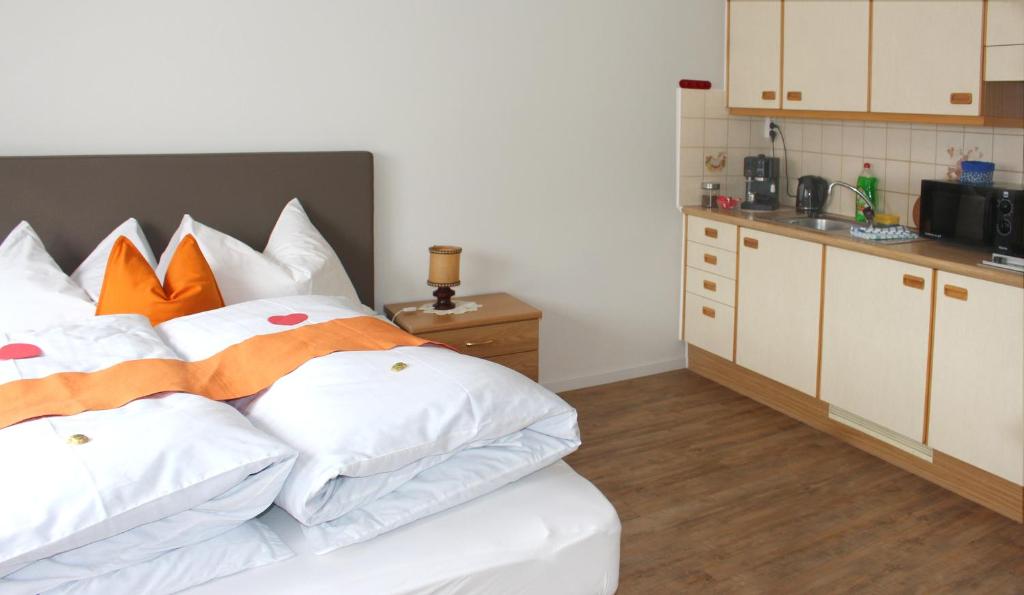 una camera da letto con un letto con cuscini arancioni e bianchi di Villa Malus a Castelbello