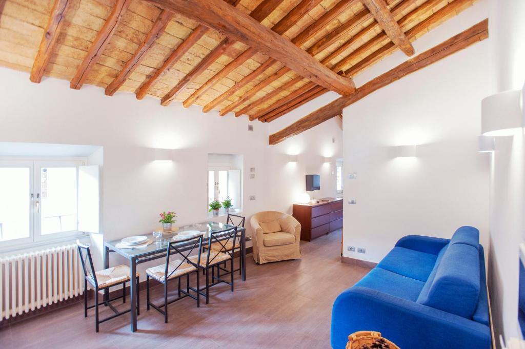 sala de estar con sofá azul, mesa y sillas en Domizio, en Roma