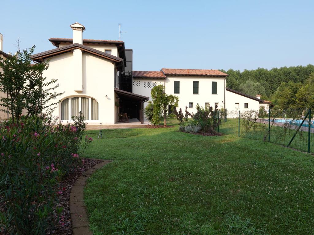 a large white house with a grass yard at Ca' Dei Molini in Gruaro