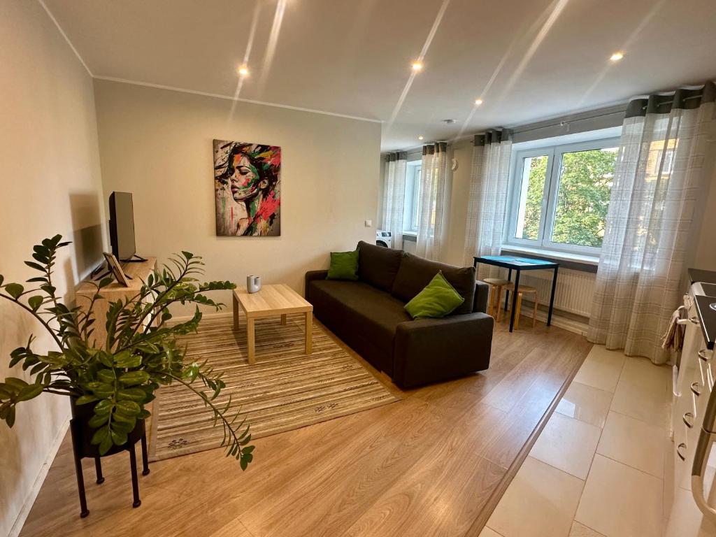 a living room with a couch and a table at Central Location Apartment with Wide Bath in Tallinn