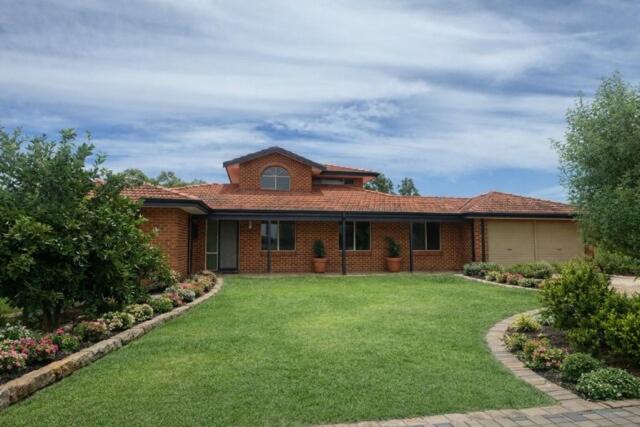 a brick house with a lawn in front of it at Sittella's Vineyard Residence in Herne Hill