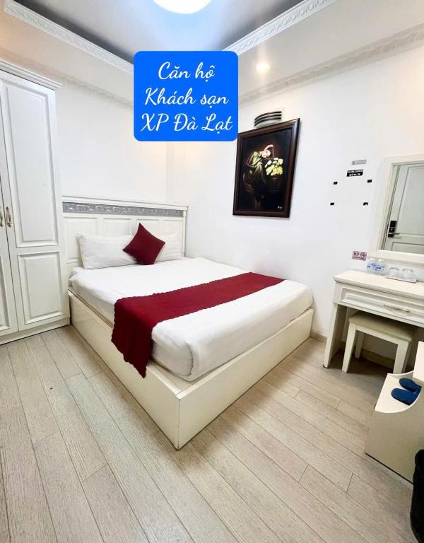 a bedroom with a large bed with a sign above it at Khách Sạn Căn Hộ XP -Đà Lạt in Da Lat