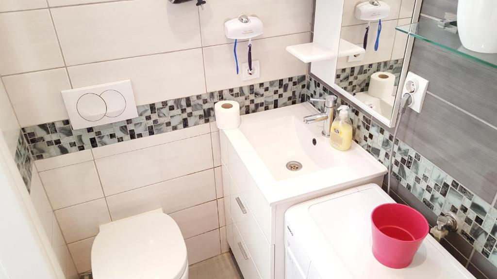 a white bathroom with a sink and a toilet at Apartment Kiki in Kotor
