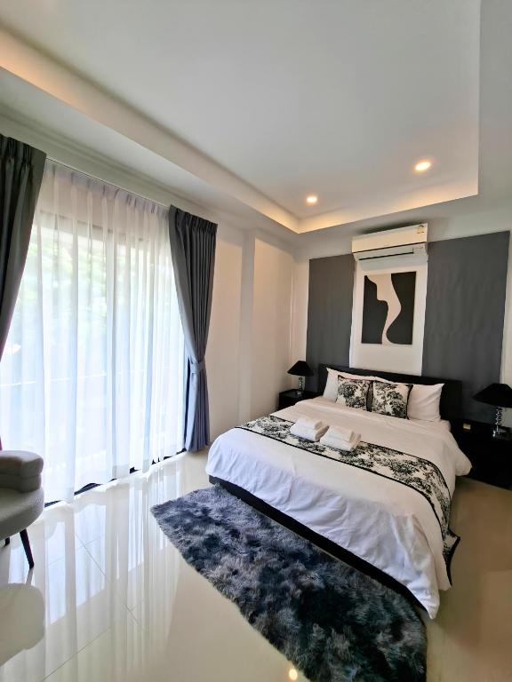 a bedroom with a large bed and a large window at Sunday House - Fisherman Village Samui in Bophut