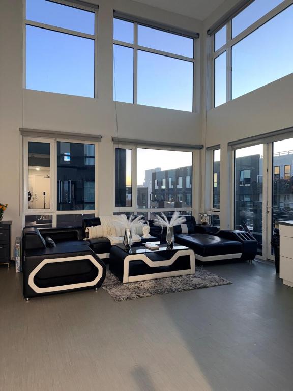 a large living room with black furniture and large windows at Moonlit Serenity 2 in Oakland