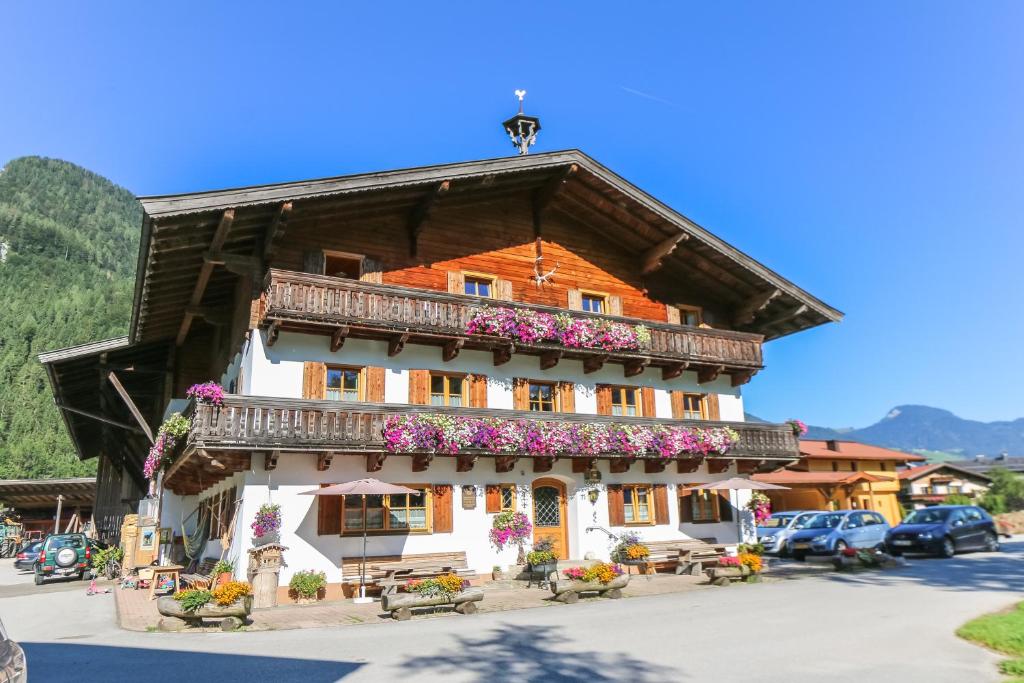 ein Gebäude mit Blumen davor in der Unterkunft Frühstückspension Müllergut in Sankt Martin bei Lofer