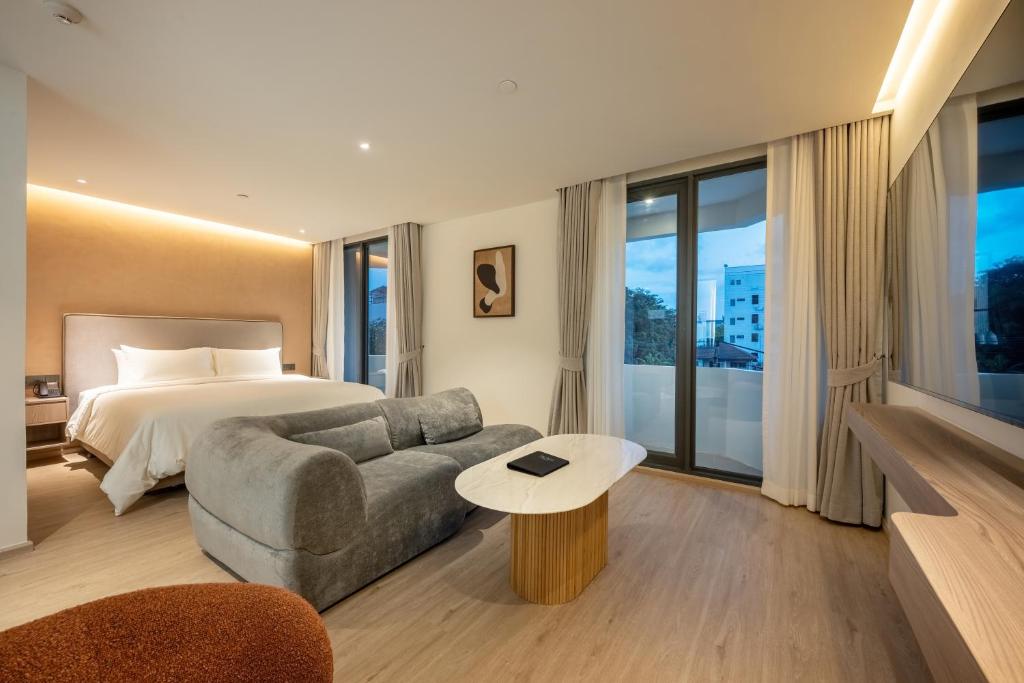 a hotel room with a bed and a couch at ROYS Hotel Bangkok in Bangkok
