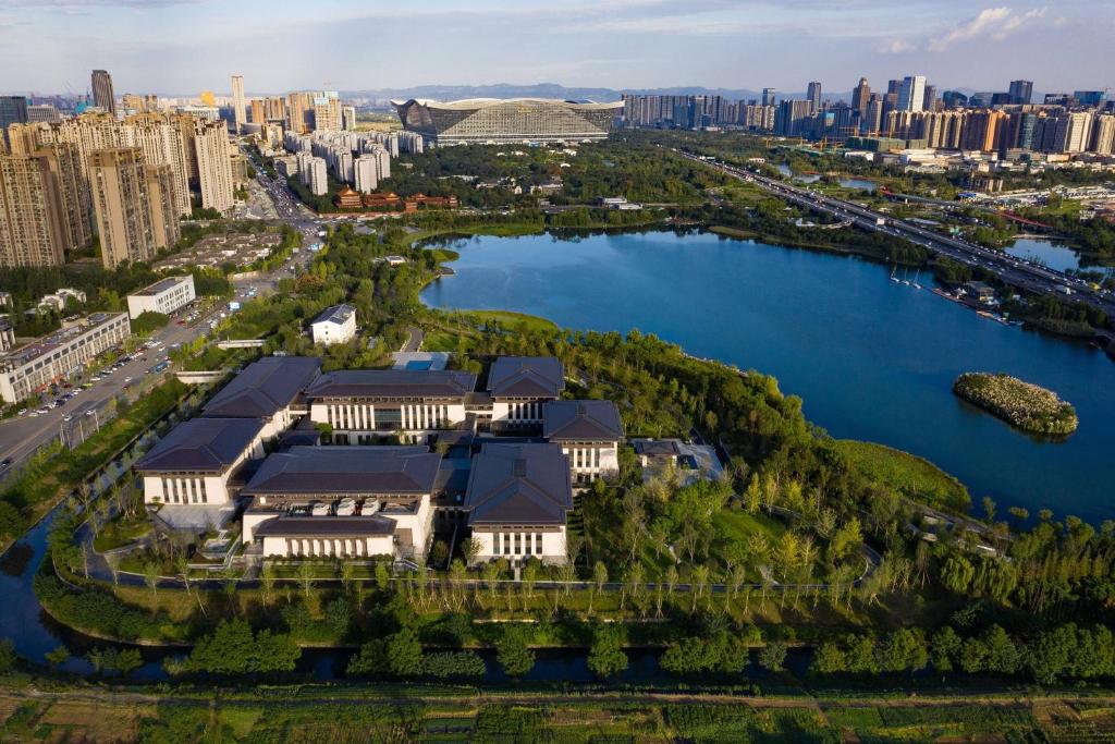 an aerial view of a building on a lake with a city at Gran Meliá Chengdu in Chengdu