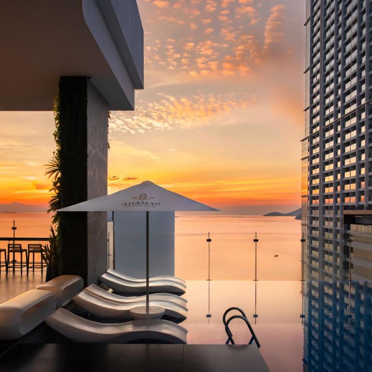 a view of the ocean from a hotel pool with an umbrella at Adamas Boutique Hotel Nha Trang in Nha Trang