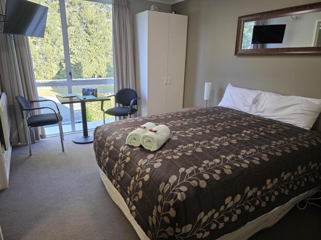 a hotel room with a bed with towels on it at Opuke Studio Methven in Methven