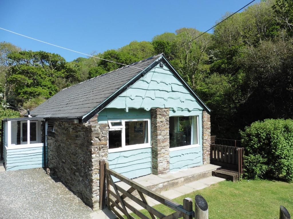 a small cottage with a blue building at The Old Shippon in Bude