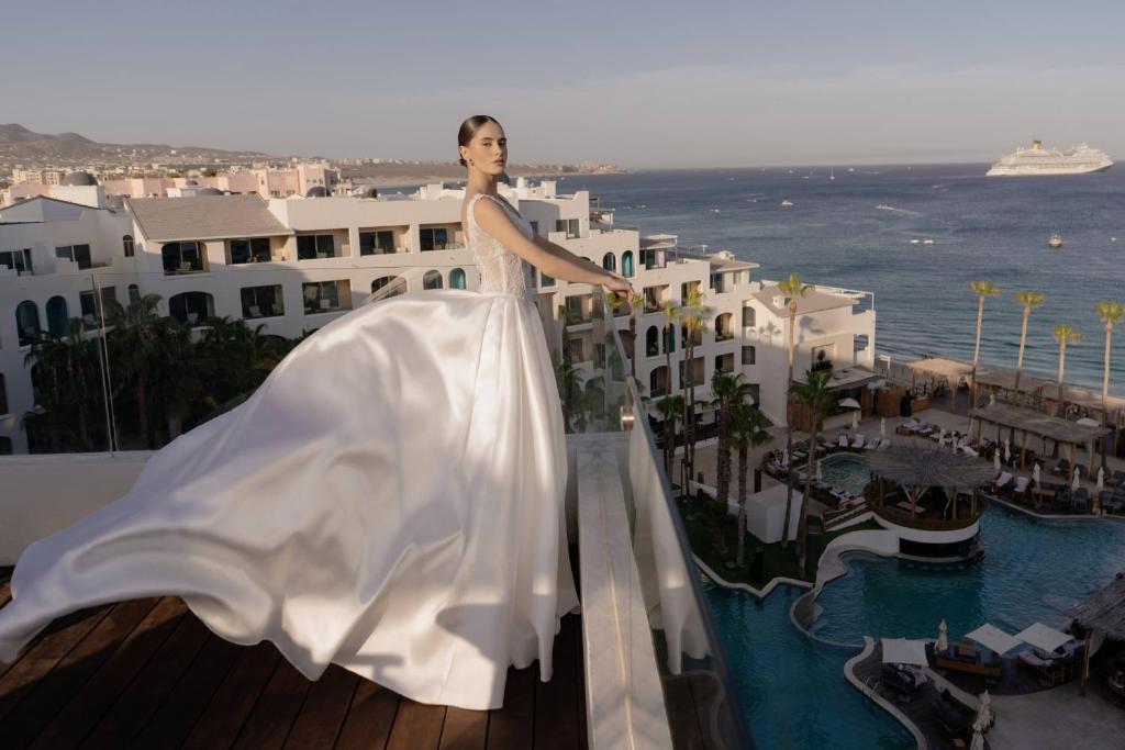 a woman in a white dress standing on top of a building at ME by Meliá Cabo - Adults Only in Cabo San Lucas