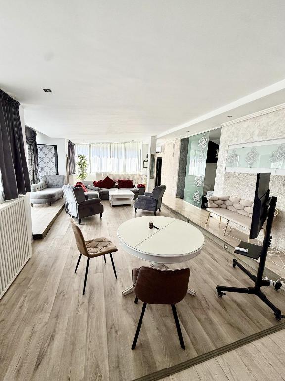 a living room with a white table and chairs at Hotel Jolie Apartments in Galaţi