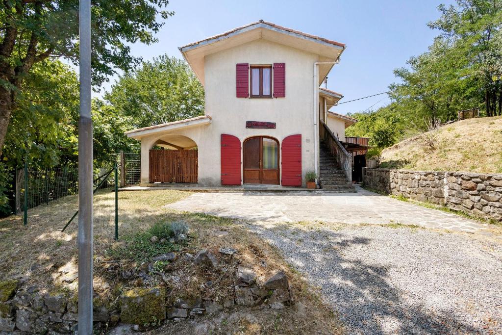 a house with red shutters on a hill at La Pennica bnb in Pontremoli