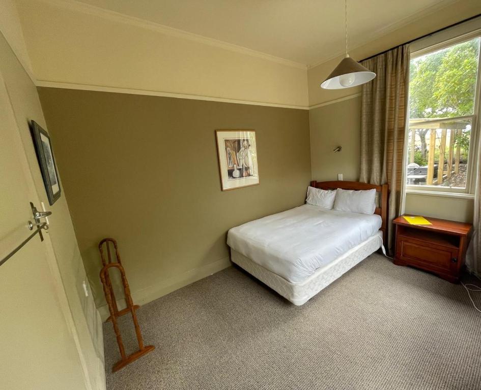 a bedroom with a white bed and a window at Central Otago Hydeaway in Hyde