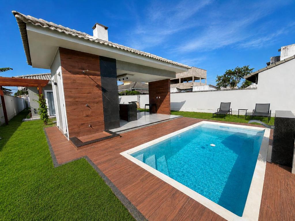 a swimming pool in the backyard of a house at Beach Loft - Design e Estilo in Maricá
