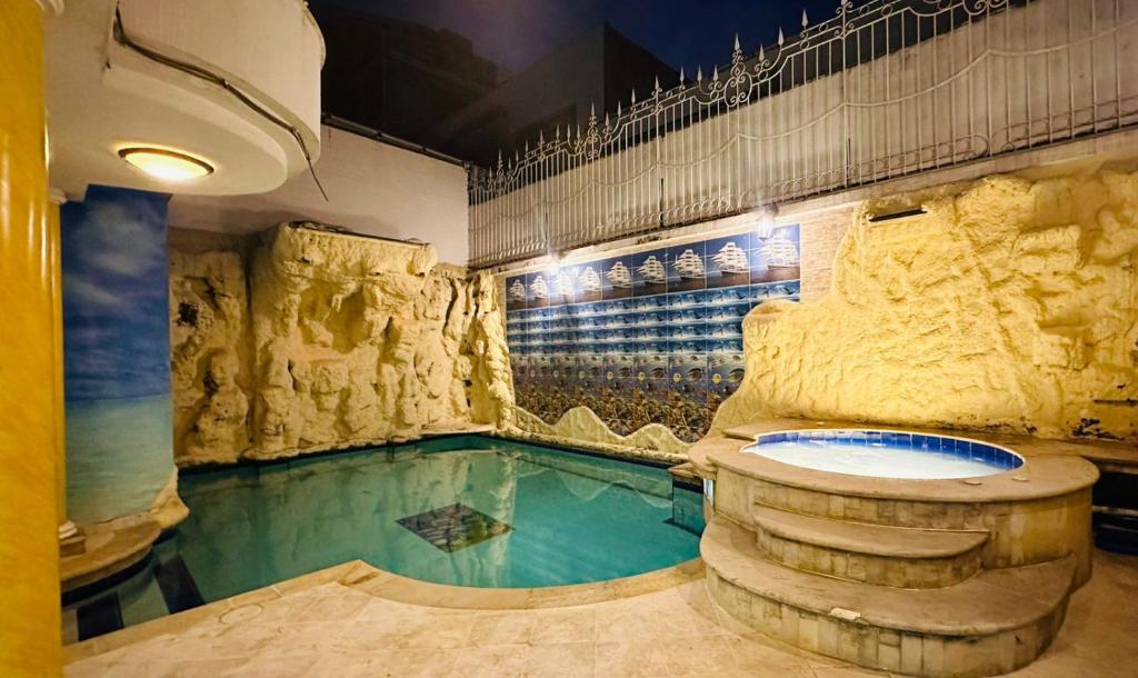 a swimming pool with a bath tub in a room at Hotel Casa Sharon in Cali