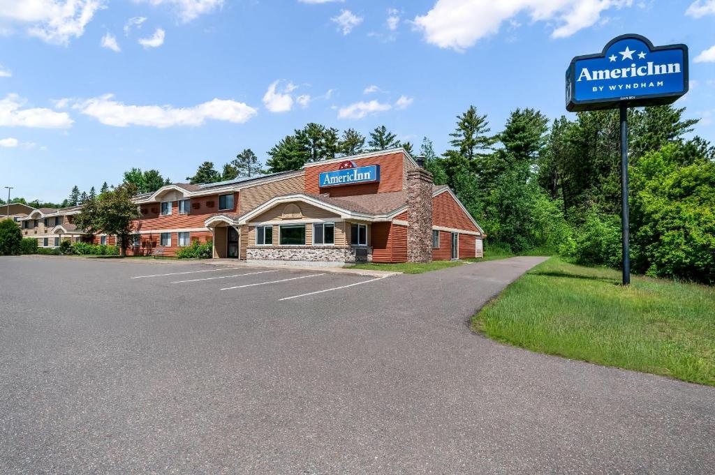 a building with a sign in front of it at AmericInn by Wyndham Cloquet in Cloquet
