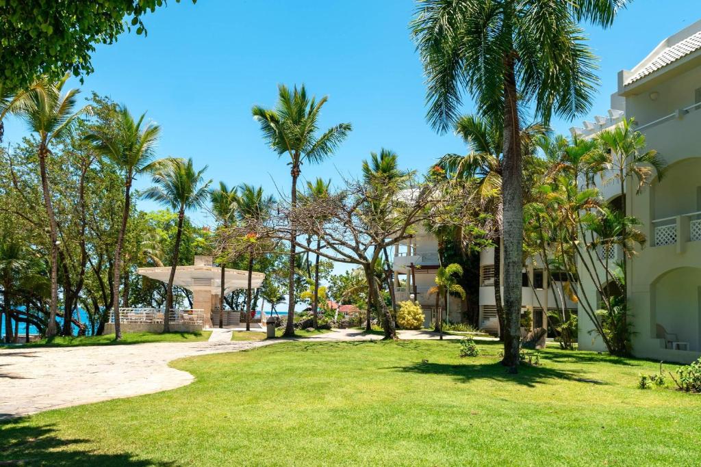 a park in front of a building with palm trees at Casa Marina Sosua, Trademark by Wyndham All Inclusive in Sosúa