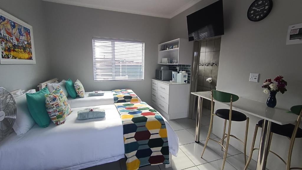 a small bedroom with a bed and a kitchen at 27 on Brunswick in Gqeberha
