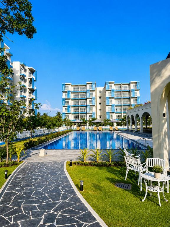 a swimming pool in front of some apartment buildings at Signature 2BR - Deluxe - Santorini - Negombo in Negombo