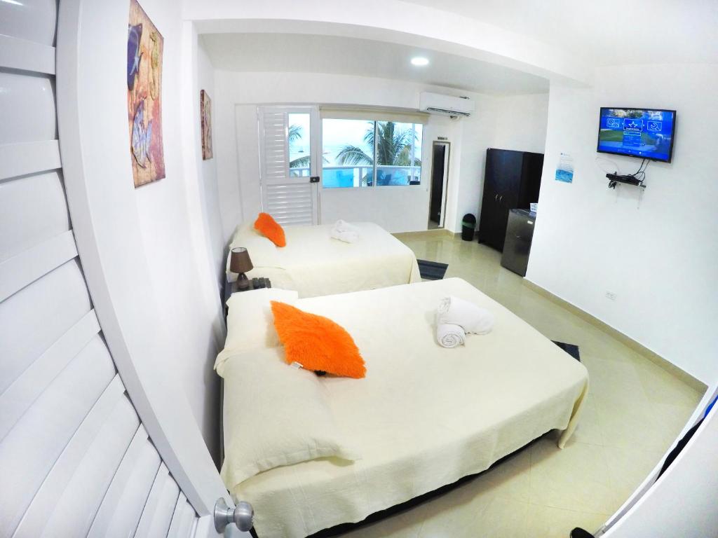 a hotel room with two beds and a tv at Hotel Molino de Viento in San Andrés