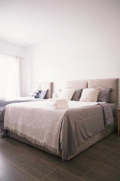 a bedroom with a large bed with white sheets at Prouds House in Ban Hua Phlong