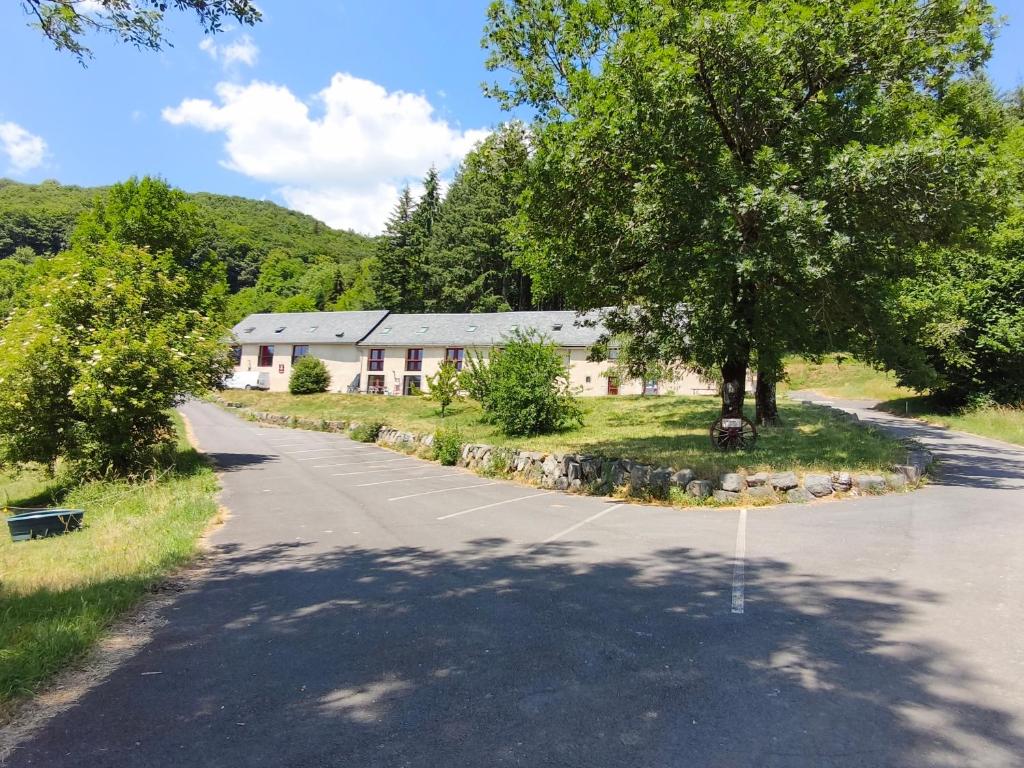an empty road in front of a building with a tree at Gite la Borie de Pourtou Santoire in Condat
