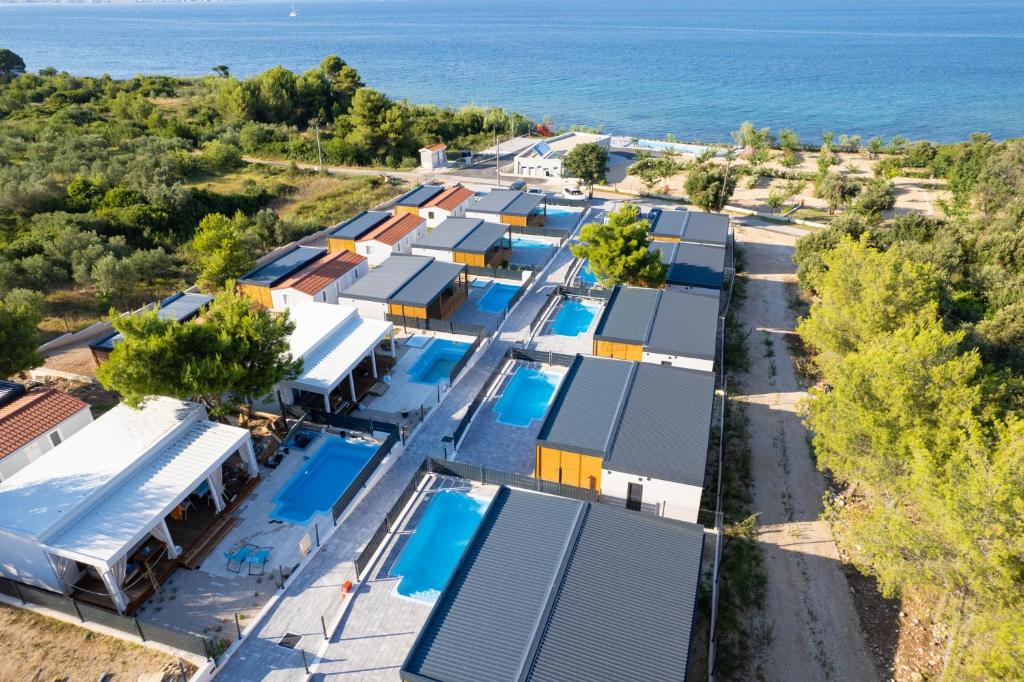 an aerial view of a row of houses next to the ocean at Camping Nevia - Mobile Homes with Heated Private Pool in Neviđane
