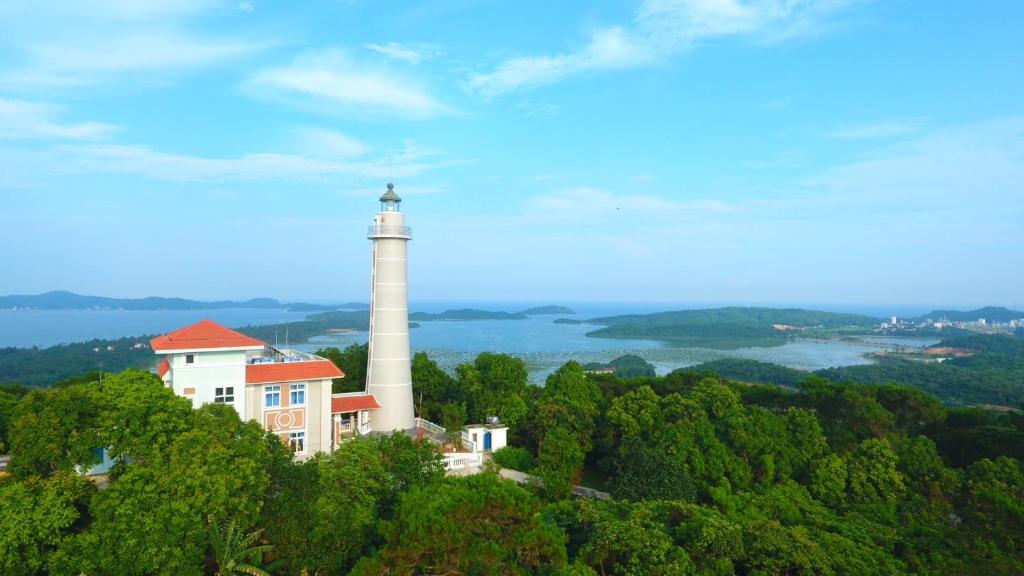 a lighthouse on top of a hill with a house at Mẹ Nhím homestay in Chung Cap