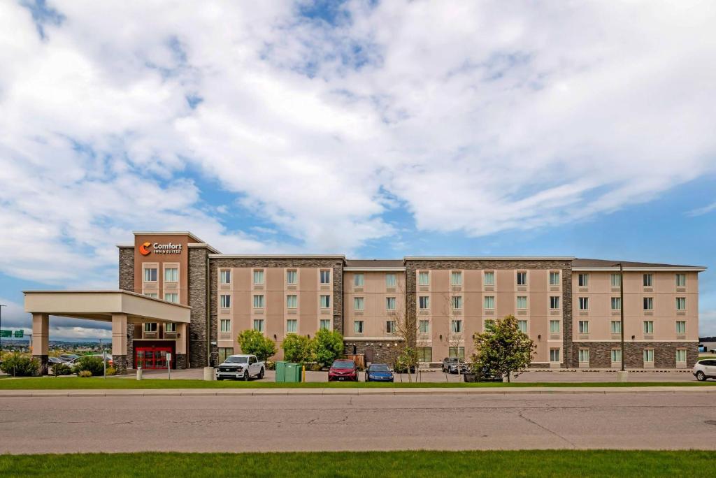 a large building with a gas station in a parking lot at Comfort Inn & Suites Airport North in Calgary