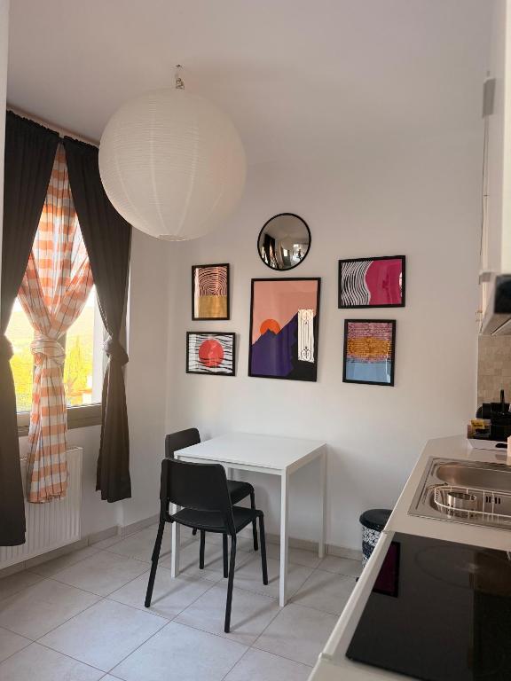 a white table and chairs in a kitchen with pictures on the wall at The nest in Kalavrita
