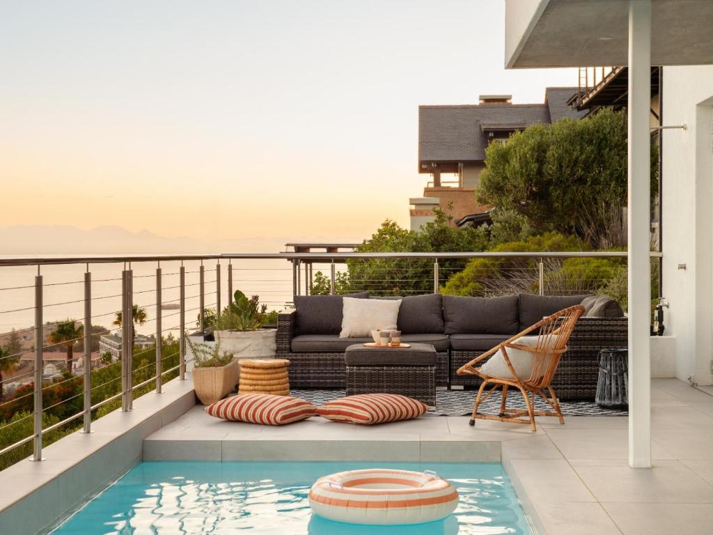 a patio with a couch and a swimming pool at The Lighthouse in Simonʼs Town