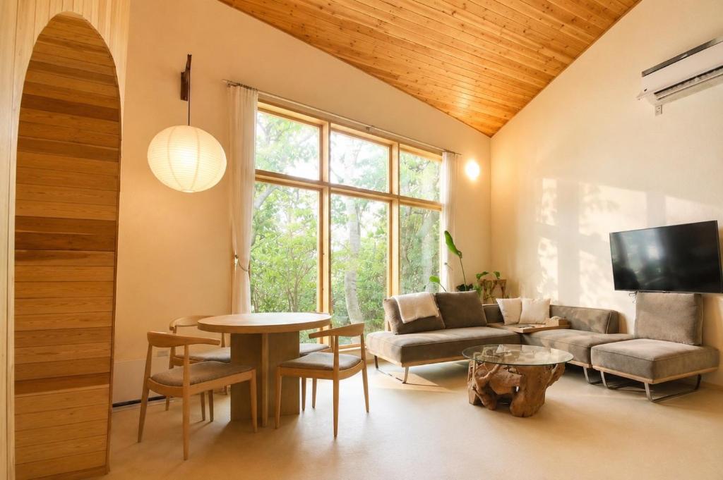 a living room with a couch and a table at Villa KULM in Minamiawaji