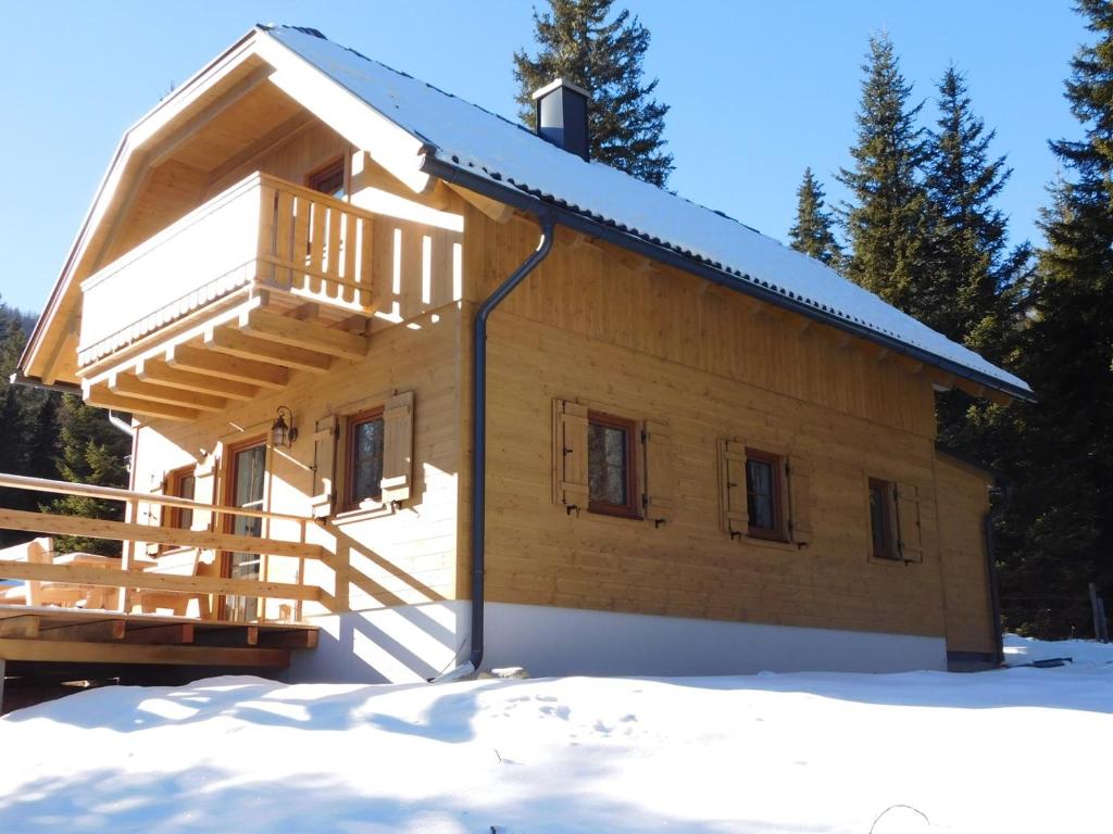 ein Blockhaus mit Balkon im Schnee in der Unterkunft Almhütte-Flattnitz in Flattnitz