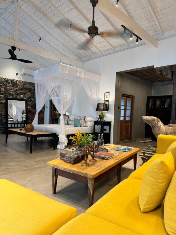 a living room with a yellow couch and a table at Palace Bope Galle in Galle