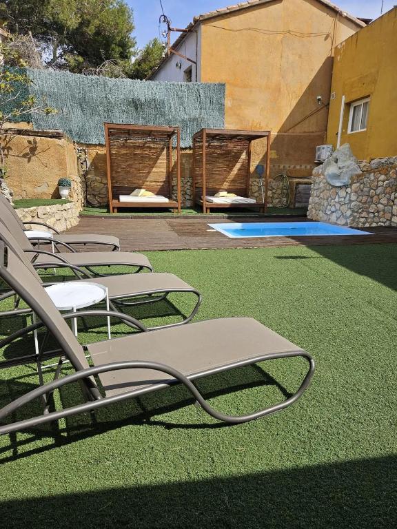 a group of lawn chairs sitting on the grass at Spacious House in Can Trabal in Can Trabal