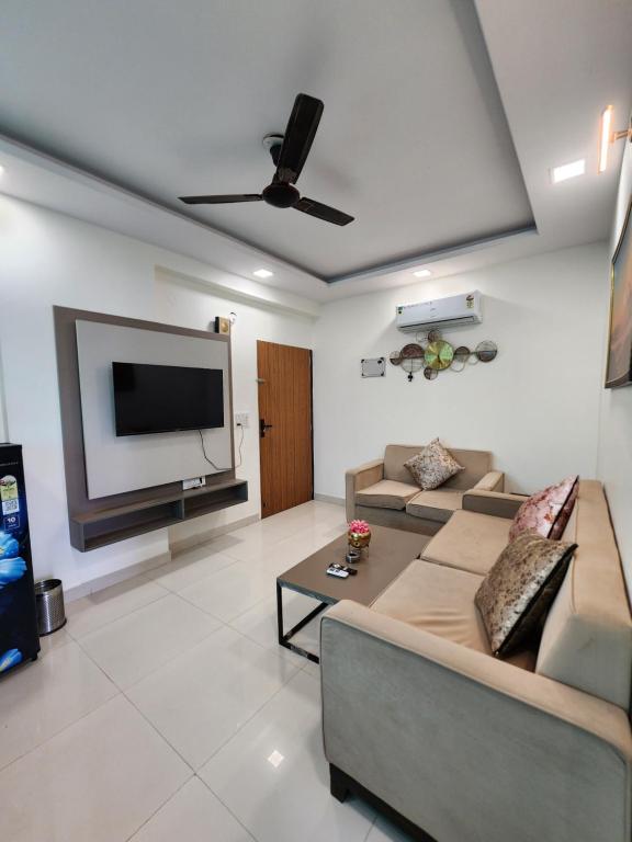 a living room with a couch and a flat screen tv at Shivara Homes in Jaipur